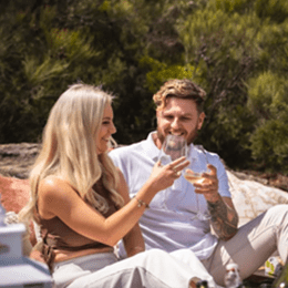 Couple cheersing drinks at a luxury picnic in the Blue Mountains